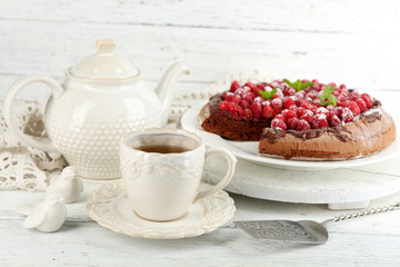 Piece of cake with chocolate Glaze and raspberries on color wooden background