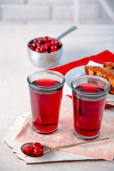 Two glasses with cherry juice on table, on light background