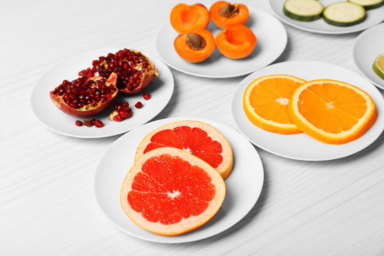 Different products on saucers on wooden table close up