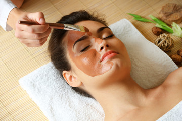 Obraz na płótnie Canvas Portrait of young woman while facial cosmetic procedure in spa salon