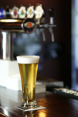 Fototapeta na wymiar Cold beer glass on bar or pub desk