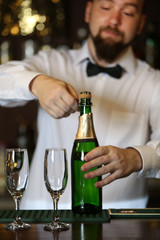 Portrait of handsome bartender with champagne bottle