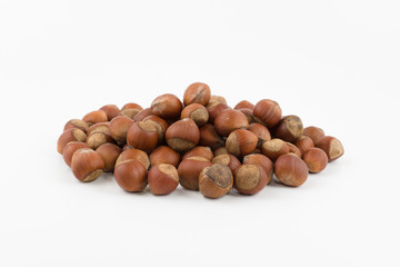 hill of hazelnuts in a shell lies on a white background