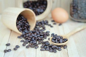 Fototapeta na wymiar coffee bean and egg on the wood floor , selection focus point coffee bean on wooden spoon