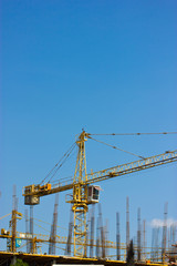Construction site with crane isolated on blue sky.