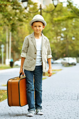 Little boy with suitcase in the park