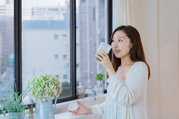 スムージーを飲むパジャマ姿の女性
