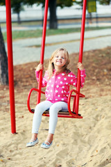Little girl having fun on swing, outdoor