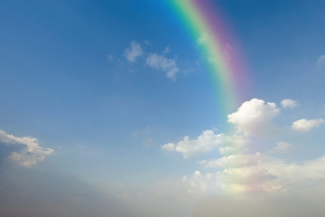 Clear blue sky with white cloud and rainbow