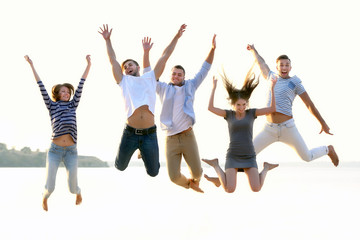 Obraz premium Young people with beer on the riverside