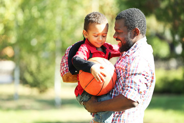 Father and son playing with ball outside