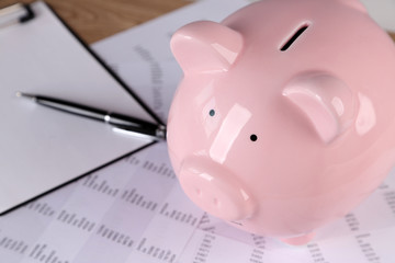 Pig moneybox and calculating equipment on desk closeup