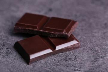 Dark chocolate pieces on  dark gray background