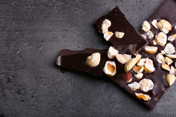 Black chocolate pieces and nuts on dark gray background