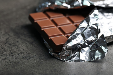 Chocolate bar in foil  on gray background