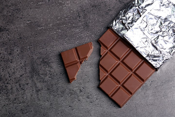 Chocolate bar in foil  on gray background