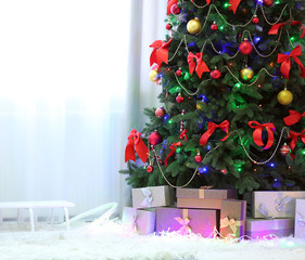 Perfect Christmas tree with gifts underneath in living room © Africa Studio