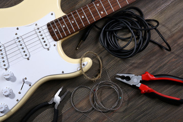 Electric guitar with musical equipment on wooden background