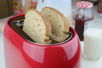 red toaster with two whole wheat bread in the pockets