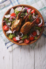 roasted quail and fresh vegetables. vertical top view
