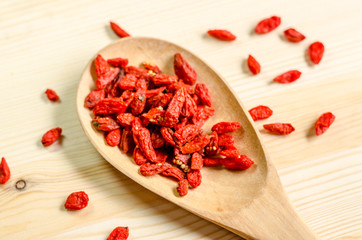 Dried goji berries on wooden tablespoon