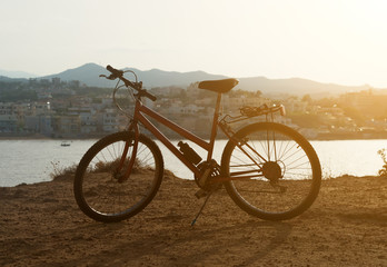 Fototapeta premium Red bicycle on the hill at sunset.
