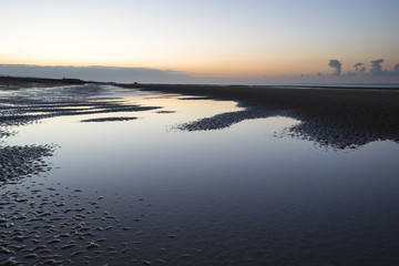 Beautiful tranquil sunrise over low tide beach