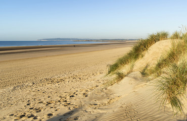 Beautiful sunrise over sand dunes system on yellow sand golden b