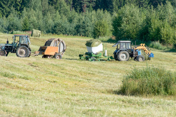 Tractors mow grass and packed