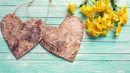 Yellow daffodils flowers  and  two rustic decorative hearts