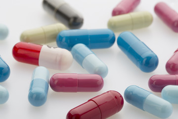 Colorful medicine capsules on white background