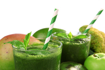 Green healthy juice with fruits and vegetables on gray background
