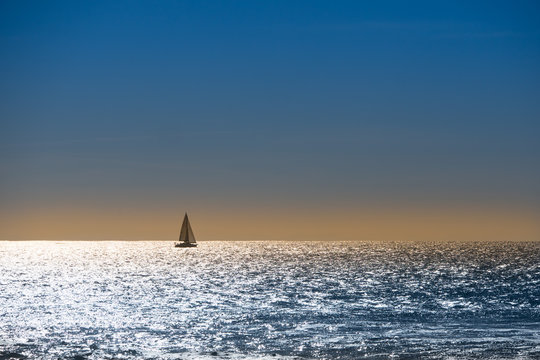 Fototapeta Sailboat navigates at sunset