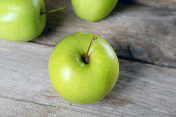 Ripe green apples on wooden table close up