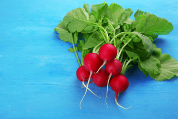 Fresh red radish on color wooden background
