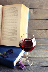 Beautiful composition with glass of wine with old books on table close up
