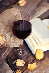 Beautiful composition with glass of wine with old book on table close up