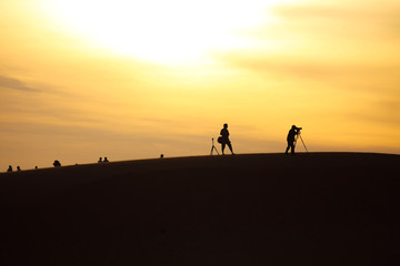 Photo of sand dunes with travellers