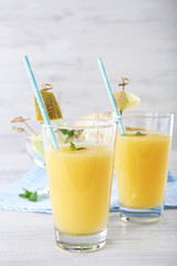 Glasses of melon cocktail on white wooden background