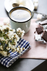 Cup of flavored coffee with chocolate on table with napkin, closeup