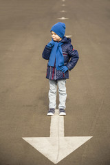 boy stands on the arrow on the road, abstraction