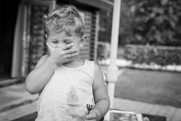 little boy child laughing with his hand covering his face © Niels