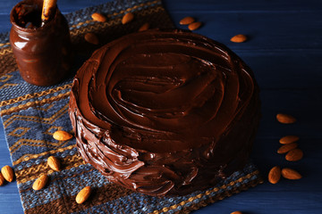 appetizing chocolate cake among almonds on blue background