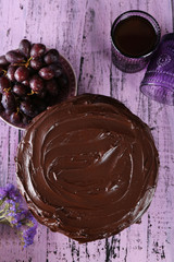 tasty chocolate pie with sweet grape and glass of tea on wooden background