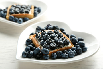 Gourmet fresh blueberry tarts on plates, close up