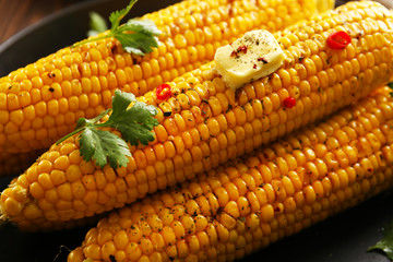 Tasty grilled corn with vegetables and fresh butter, close up