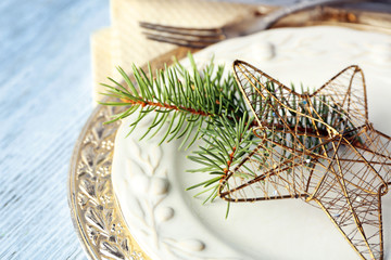 Empty plate, cutlery, napkin and glass on rustic wooden background. Christmas table setting concept