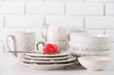 Clean dishes on table on brick wall background