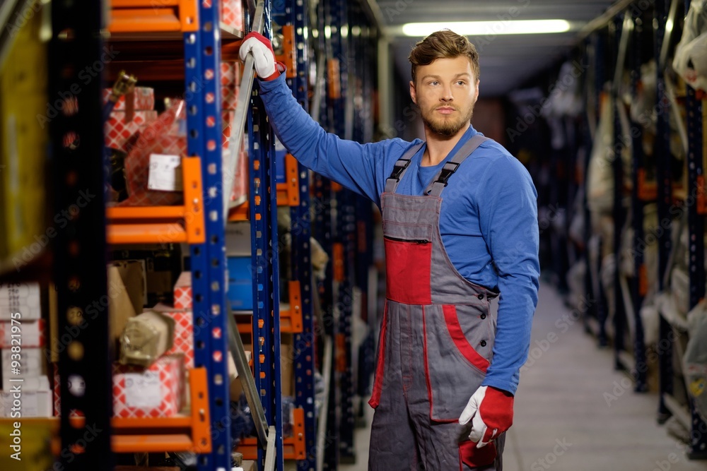 Wall mural Worker on a automotive spare parts warehouse