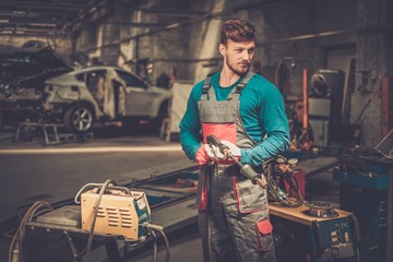 Mechanic with welding machine in a workshop